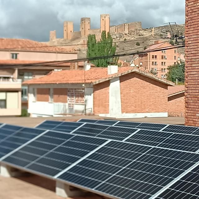 Placas solares en una cubierta de Molina de Aragón con el castillo al fondo