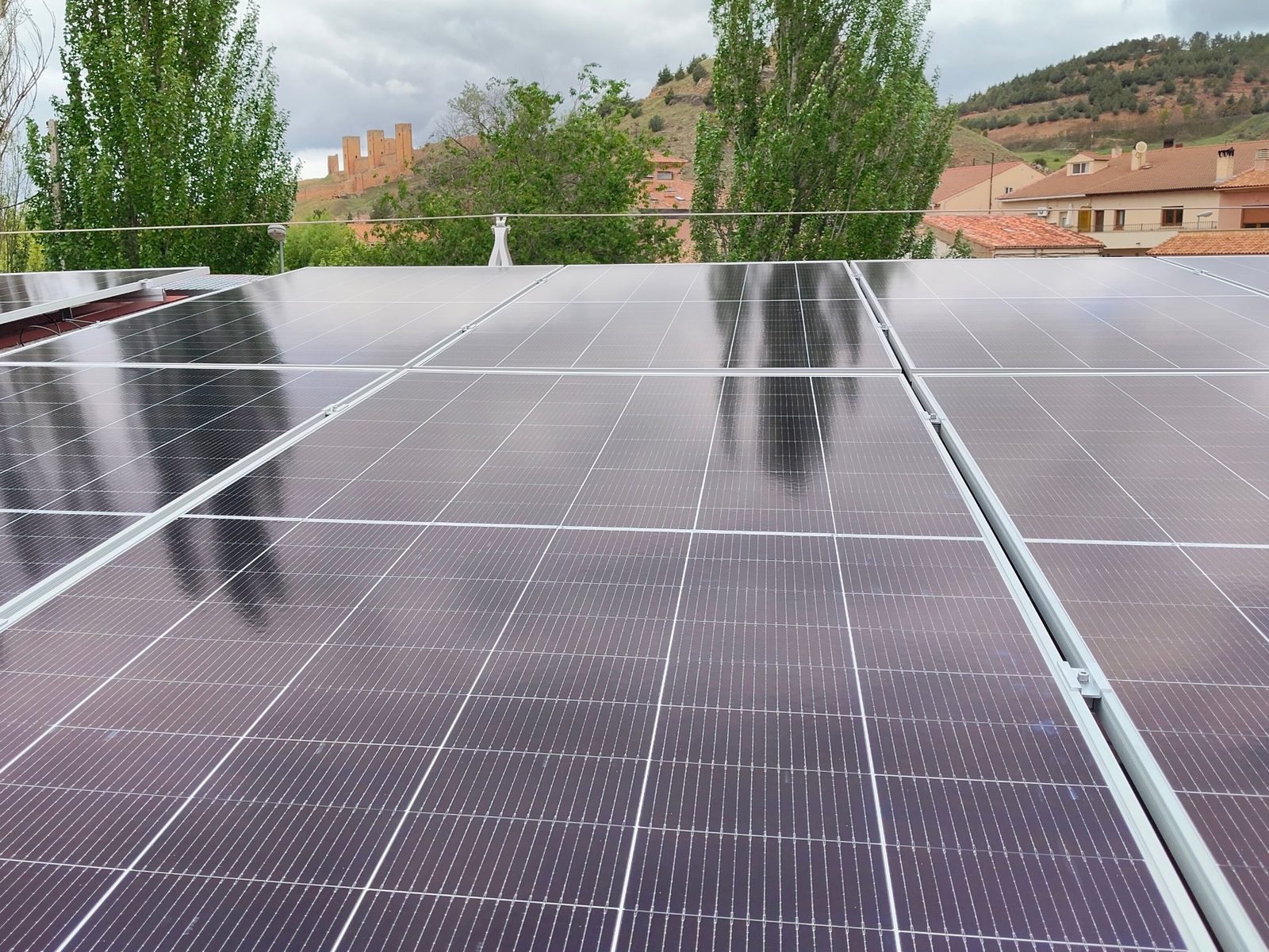 Placas solares en una cubierta de Molina de Aragón con el castillo al fondo